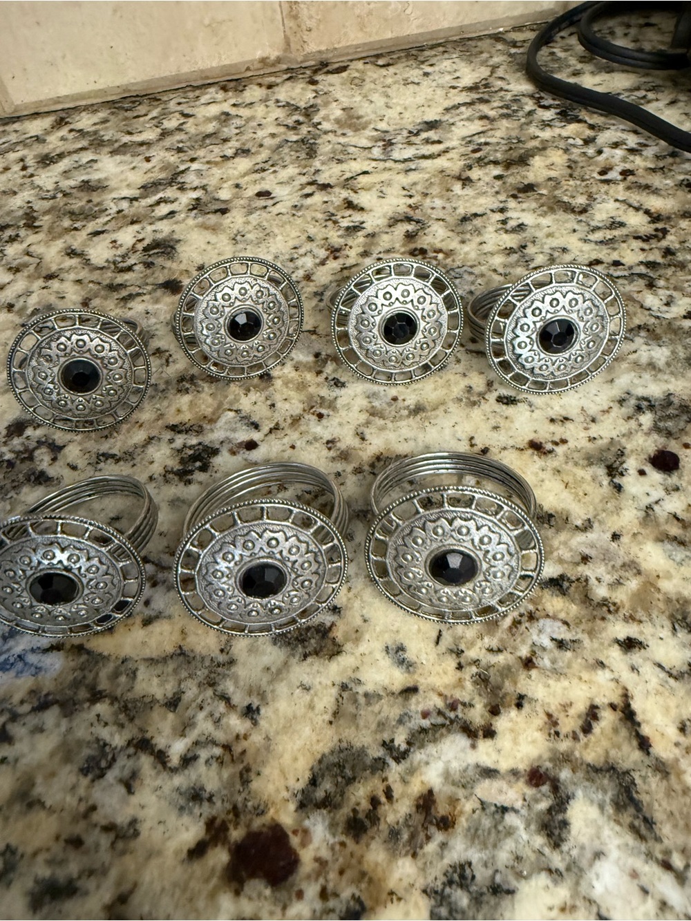 Set of  7 Silver-Tone Decorative Napkin Rings with Black Center